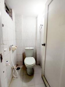 een witte badkamer met een toilet en een douche bij New Hotel Labbaik in Dhaka