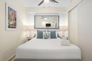 a bedroom with a large white bed with blue pillows at Prime Location at Condado Beach 1br 1ba - Apt 8 in San Juan