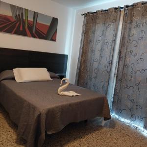 a bedroom with a bed with a swan on it at Apartamento arguineguin in Mogán