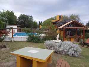 a picnic table in a yard with a pool at Cabañas Esferas de Cristal in Capilla del Monte