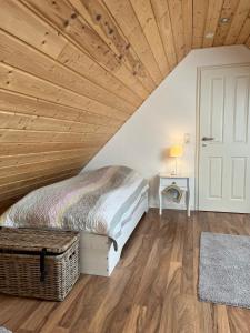 um quarto com uma cama e um tecto de madeira em Haus Deichkind em Krummhörn