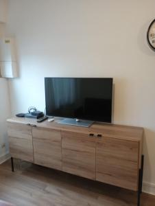 a flat screen tv sitting on top of a wooden cabinet at F2 tout équipé proche du centre in Beauvais