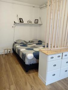 a bedroom with a bed with a white dresser and a staircase at F2 tout équipé proche du centre in Beauvais