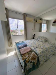 um quarto com uma cama com almofadas em Apartamento próximo da praia em São José de Ribamar