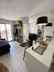uma cozinha e sala de estar com um balcão branco em Apartamento próximo da praia em São José de Ribamar