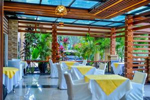 a dining room with white tables and white chairs at Hill View Hotel Kiyovu in Kigali