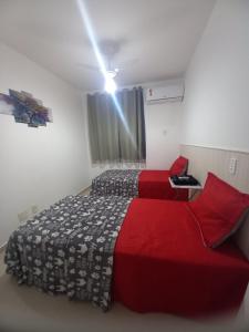 a bedroom with two beds and a light on the ceiling at Apartamento próximo da praia in São-José-do-Ribamar