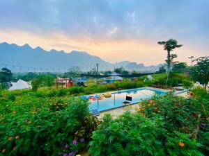 een zwembad in een tuin met bergen op de achtergrond bij Wind Hill Campsite in Ha Giang
