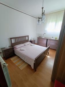 um quarto com uma cama grande e pisos em madeira em Betty casa vacanze em Aradeo