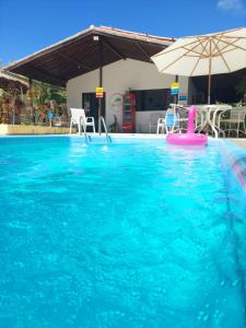 a swimming pool with a pink item in the water at Flor de Lótus Suites in Tamandaré