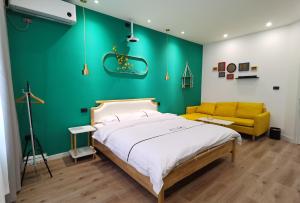 a bedroom with a bed and a green wall at Enshi Miaoer One Residence in Enshi
