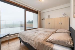 ein Schlafzimmer mit einem großen Bett und einem großen Fenster in der Unterkunft Riverside 0902 in Nieuwpoort