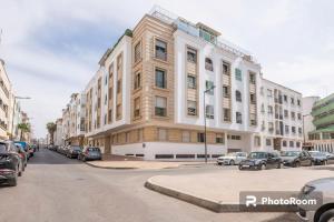 a large building on a city street with parked cars at Appartement Rabat Agdal City Centre in Rabat