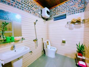 een badkamer met een wit toilet en een wastafel bij Wind Hill Campsite in Ha Giang