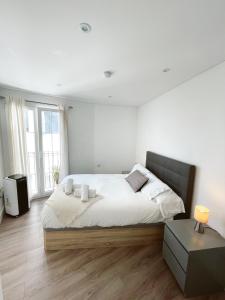 a white bedroom with a large bed and a window at Modern City Centre Two Bedroom Windsor Apartment - Grand Central House in Gibraltar