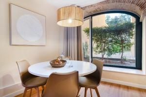 uma sala de jantar com uma mesa e cadeiras brancas e uma janela em Metropolitan Living Lisbon - Laranjeiras em Lisboa