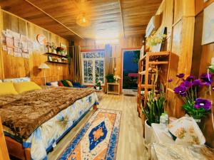 een slaapkamer met een bed en een kamer met bloemen bij Wind Hill Campsite in Ha Giang