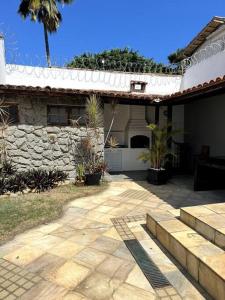 ein Haus mit einer Steinmauer und einer Terrasse in der Unterkunft Casa com Piscina ao lado do Shopping in Cabo Frio