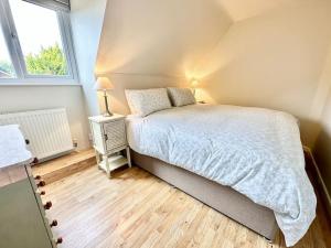 een kleine slaapkamer met een bed en een raam bij Greenacre Lodge - cosy, dog-friendly rural home with private garden in Redgrave