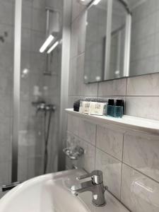 bagno con lavandino, specchio e doccia di The Steakhouse - Guest Rooms a Sankt Johann im Pongau