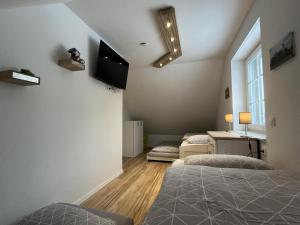 a bedroom with two beds and a flat screen tv at AlleenHuus in Warin