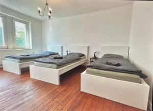 2 camas en una habitación con suelo de madera en Doppelbett Unterkunft Vahrenwald-List en Hannover