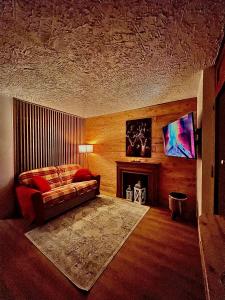 ein Wohnzimmer mit einem Bett und einem Kamin in der Unterkunft Home Sauze d Oulx in Sauze d'Oulx