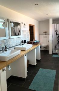 a bathroom with two sinks and a toilet at Haus Deichkind in Krummhörn