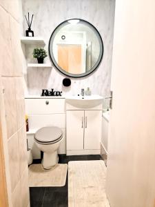 a bathroom with a white toilet and a mirror at Flat 16 Homedale house in Sutton