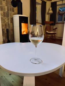 a glass of wine sitting on a table with a fireplace at Haus Deichkind in Krummhörn