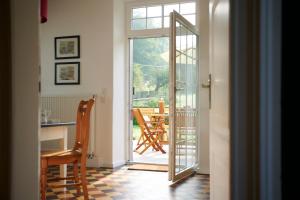 an open door to a patio with a table and chairs at Charmantes Forsthaus beim Sorpesee 