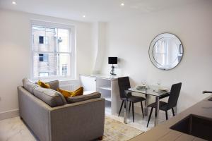 a living room with a couch and a table at Luxury Harley Street Apartments in London