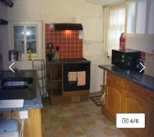 a kitchen with a sink and a stove top oven at Vinny Cottage in Owermoigne