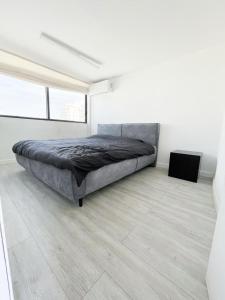 1 dormitorio con 1 cama grande en una habitación blanca en Beach house en Netanya