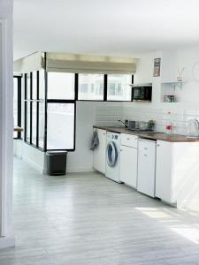a large white kitchen with a washer and dryer at Beach house in Netanya