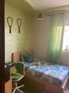 - une chambre avec un lit, une chaise et un bureau dans l'établissement Bel appr, à Temara