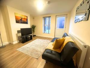 a living room with a couch and a television at Chic 2-Bed Flat Private Garden SE13 in London