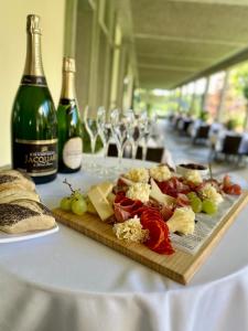 einen Teller mit Essen auf dem Tisch mit einer Flasche Wein in der Unterkunft Hotel La Longeraie in Morges