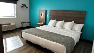 ein Schlafzimmer mit einem großen Bett mit blauer Wand in der Unterkunft The Copper Hotel - SureStay Collection by Best Western in Camp Verde