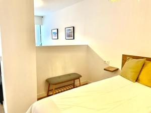 een slaapkamer met een bed en een stoel erin bij Apartamento Cervantes céntrico con garaje in Gijón