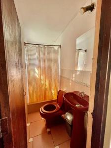 La salle de bains est pourvue de toilettes et d'un lavabo. dans l'établissement Hospedaje Rocha, à Ica