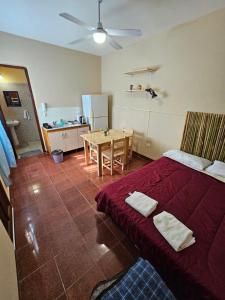 Zimmer mit einem roten Bett und einem Tisch in der Unterkunft La San Francisco III in Salta