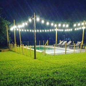 a swimming pool with lights in a park at night at Cabañas El Despertar in Puerto Iguazú