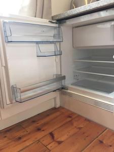 un réfrigérateur vide avec une porte ouverte et du parquet. dans l'établissement Quiet but Central Studio 409, à Nottingham