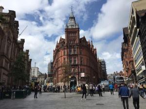 a large building with a clock tower on a city street at Quiet but Central Studio 409 in Nottingham