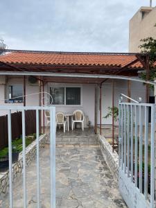 una casa con portico con sedie e tavolo di Ledjon apartament a Artemida