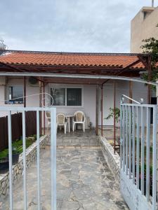 a house with a porch with chairs and a table at Ledjon apartament in Artemida