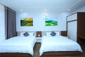 2 camas en una habitación con paredes blancas en Tam Coc LiLy Homestay, en Ninh Binh