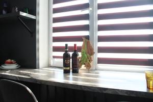 two bottles of wine sitting on a window sill at Ana's Apartment in Chişinău