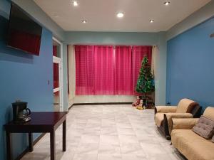 a living room with a christmas tree in front of a window at Casa Chikuwa in San Juan La Laguna